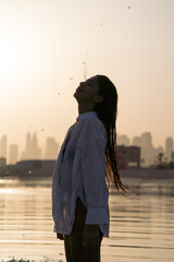 Brunette woman flicking her hair with a view on a skyline of Dubai