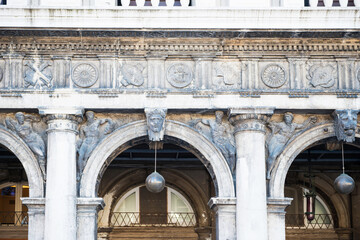 Decorative details and arches at classical facade of historical building at San Marco square in Venice, Italy
