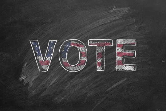 Handwritten word VOTE in blackboard. Vote in American election. American Presidential Election