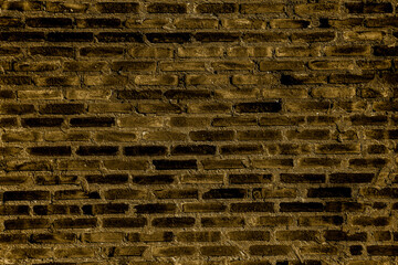 Brick wall with grout cement illuminated by a golden color light in Brazil