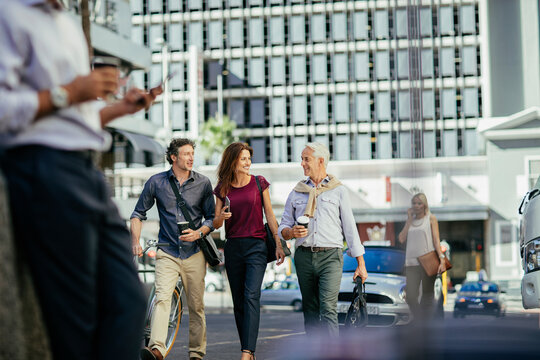 Diverse business people laughing while walking to work