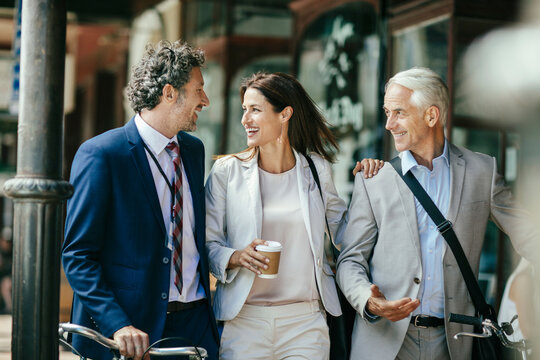 Diverse business people laughing while walking to work