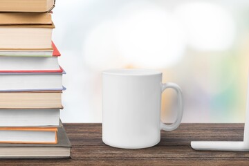 White ceramic cup and notebooks on table