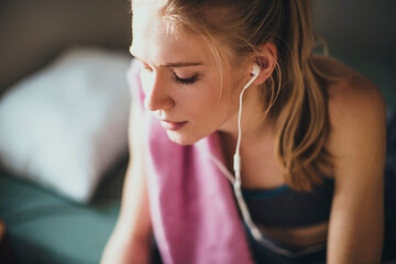 Young woman resting at home after working out and jogging in the morning