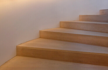 Wooden stairs leading upwards illuminated from the side