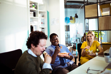 Diverse young people sharing corporate lunch at the office