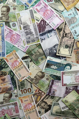 Many banknotes of different currency. Background of big amount of random money bills close up