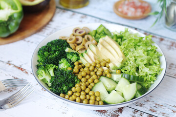 A bowl with a salad made of green vegetables