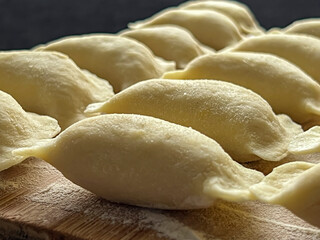 Fototapeta na wymiar Home-made dumplings, kneading the dough by hand, rolling it, cutting it out and gluing it together