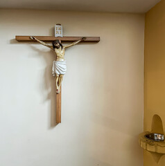 A cross at the entrance to the church and a droplet with holy water next to it.