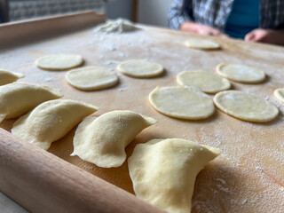 Home-made dumplings, kneading the dough by hand, rolling it, cutting it out and gluing it together