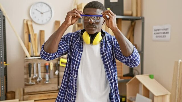 African american man donning protective gear in a carpentry workshop
