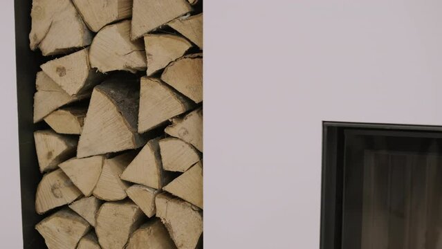 Luxurious modern design fireplace burning firewood, door with fire resistant glass window. Modern stylish fireplace and a special shelf for firewood