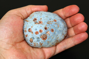 a natural stone resembling a meteorite in a man's hand © Abdulkadir