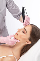 Naklejka premium Permanent make-up for eyebrows and lips of beautiful woman in beauty salon. Closeup beautician doing eyebrows tattooing. arrows on the eyes