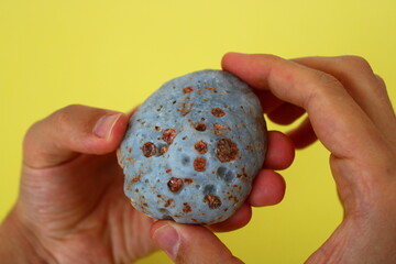 a natural stone resembling a meteorite in a man's hand © Abdulkadir