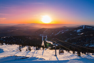 Landscape ski lift resort with snowy forest on mountain in winter sunlight, Sheregesh, Kemerovo...