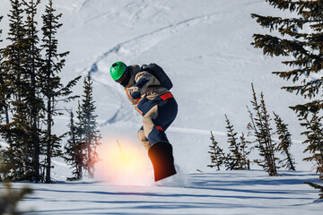 Man snowboarder rides through snow, explosion. Freeride snowboarding in Sheregesh Ski Resort on...
