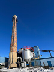 An old ceramic chimney and an old and new flue gas dust collector behind a coal boiler, a grate,...