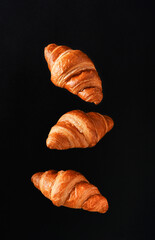 Three croissants on a black background. Levitation - 752521601
