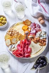 Aperitif, champagne and snack of sausage, cheese, nuts, olives and crackers on a light background. - 752527473