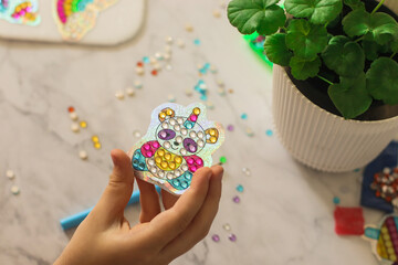 painting diamond mosaic in the hand of a child