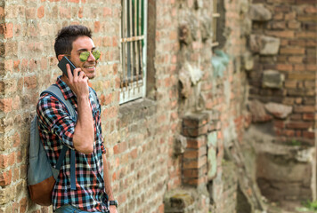 Handsome hipster talking on the phone. Close up portrait of cheerful mature man using mobile phone and laughing.