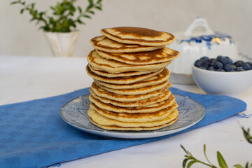 Stack of freshly prepared pancakes on a plate in a bright kitchen