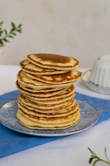 Fototapeta na wymiar Stack of freshly prepared pancakes on a plate in a bright kitchen