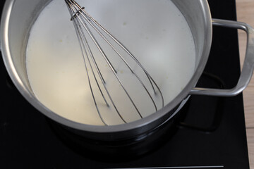 The process of frying pancakes in a frying pan. kneading pancake dough.