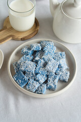 Blue candies with coconut on a light plate