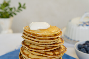 Bright yellow pancakes on a blue napkin. Big stack of pancakes