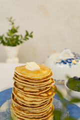 Bright yellow pancakes on a blue napkin. Big stack of pancakes