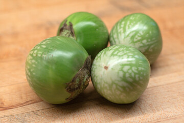 Thai Eggplants on wooden chopping cutting board.