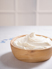 Homemade thick sour cream in a wooden bowl
