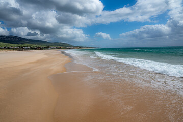 Sunny Day at a Peaceful Beach with Clear Blue Skies and Gentle Waves