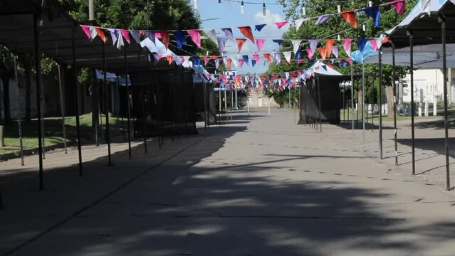 Festival de folklore  en la Pampa Sudamericana de Argentina, decoraci&oacute;n en su entrada con banderines en forma de guirnaldas, preparaci&oacute;n de los stand para los artesanos y suaves sombras en el suelo 