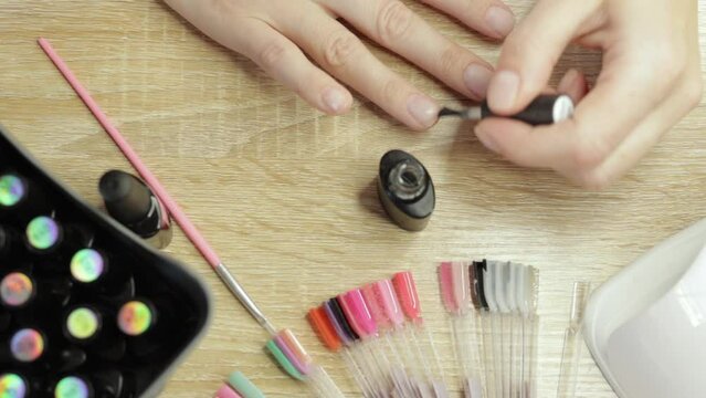 The self-sufficient woman expertly applies a base coat to her nails, demonstrating her mastery in self-manicure. This scene highlights independence and skill in nail care.