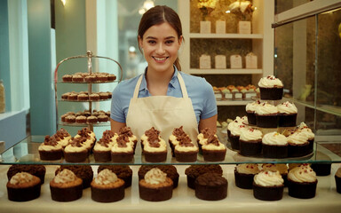 A young smiling saleswoman sells cakes