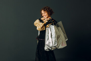 Portrait of a young adult woman dressed in a medieval dress holding shopping bags in hands
