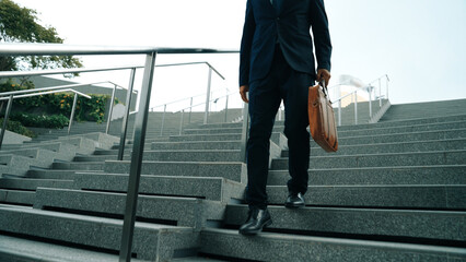 Closeup of skilled manager walking down stair with a bag and return to home. Closeup of project...
