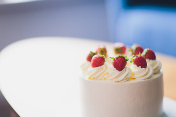 Sweet cake with strawberries on plate on wooden background.
