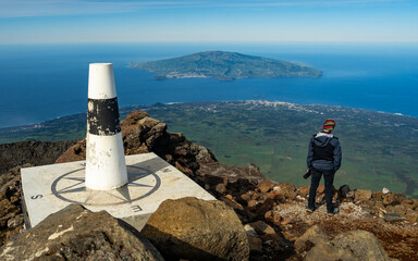 Back view of a hiker at the summit of Mount Pico. Resting and admiring the panoramic view of the...