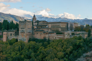 The fortress of Alhambra on a hill top seen from the quarter Albaicin with mountains of Sierra...