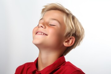 Close up portrait of a young boy smiling with his eyes closed. Perfect for family and happiness concepts