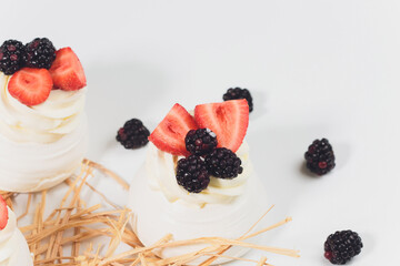 Dessert with berries on a meringue with cream.