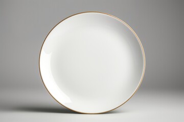 Elegant white plate with gold rim on a neutral gray background, suitable for food or kitchen-related designs