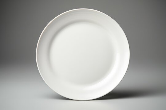 A simple white plate on a wooden table. Perfect for food photography projects