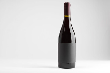 Bottle of tasty red wine on white background, space for text