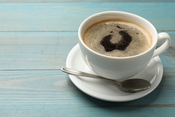 Cup of aromatic coffee on light blue wooden table, closeup. Space for text